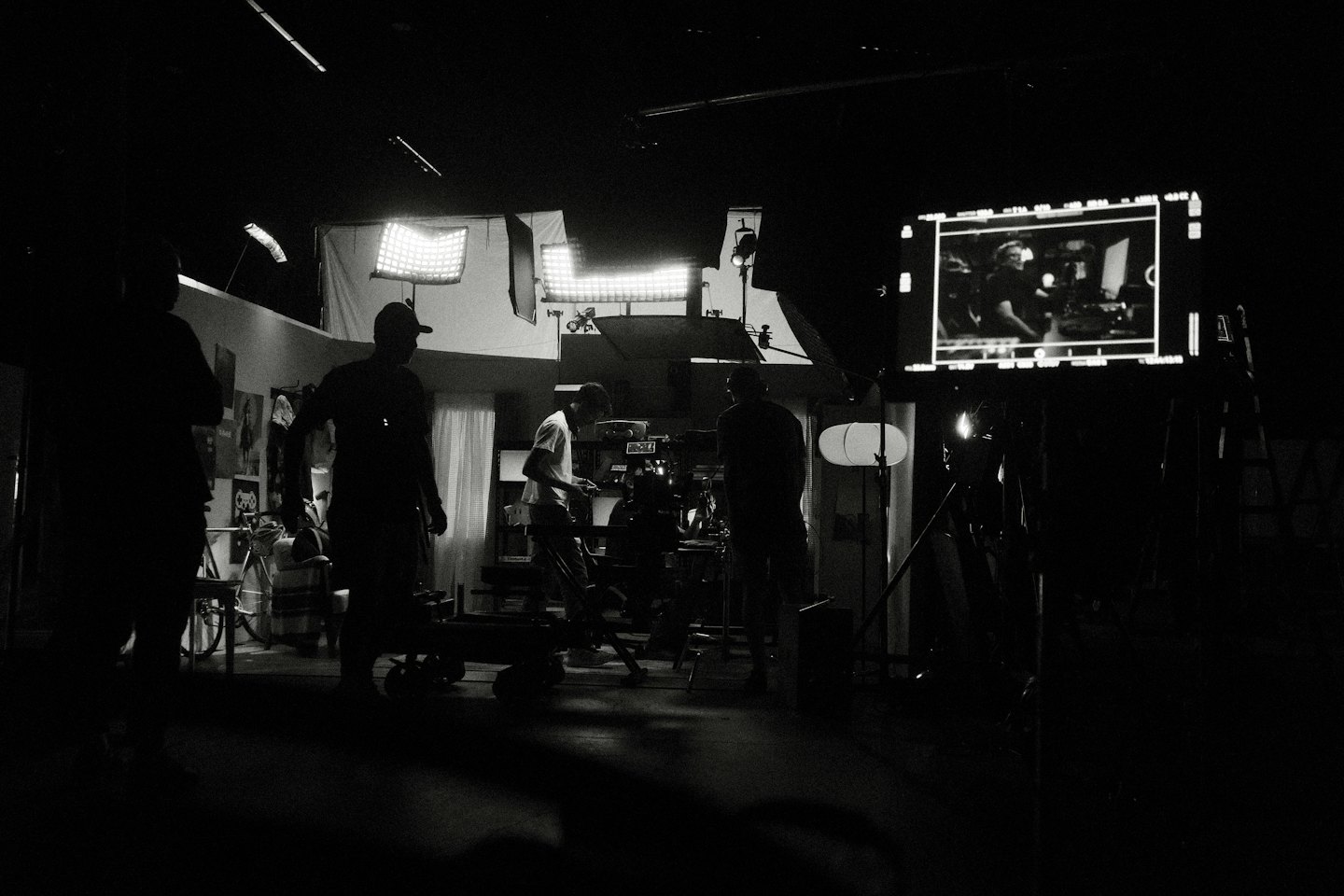 Film crew in silhouette working on a production set with equipment.